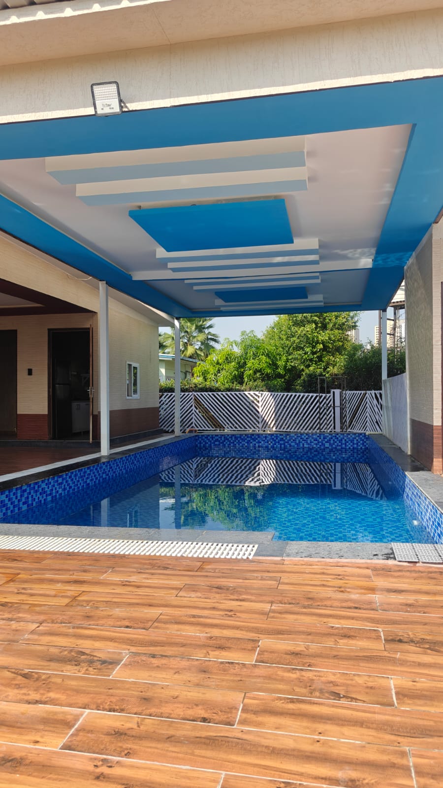 The covered pool and wooden deck by day